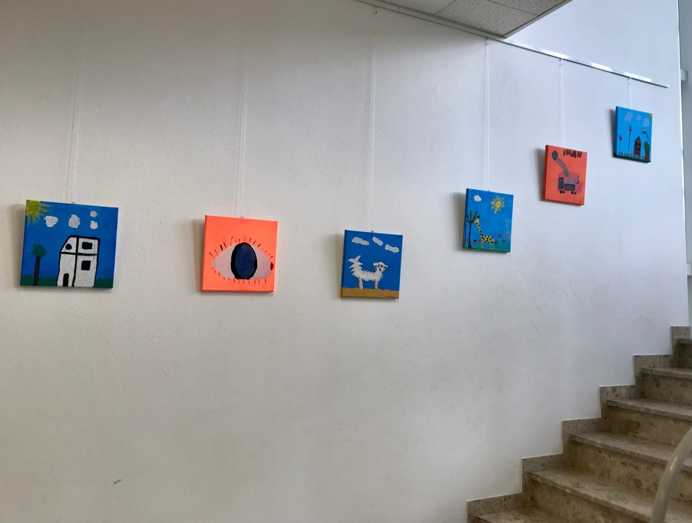 Bunte Gemälde an einer Wand, die verschiedene Tiere und Szenen darstellen.