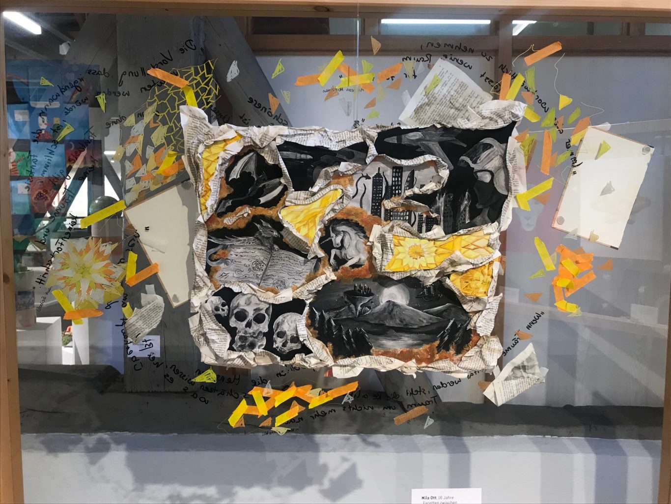 Kunstwerk mit zerfetzten Bildern und bunten, fragmentierten Elementen auf schwarzem Hintergrund.