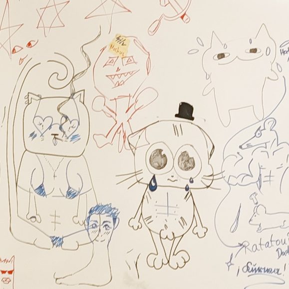 Bunte Zeichnungen von cartoonhaften Tieren und Figuren auf einer weißen Wand.