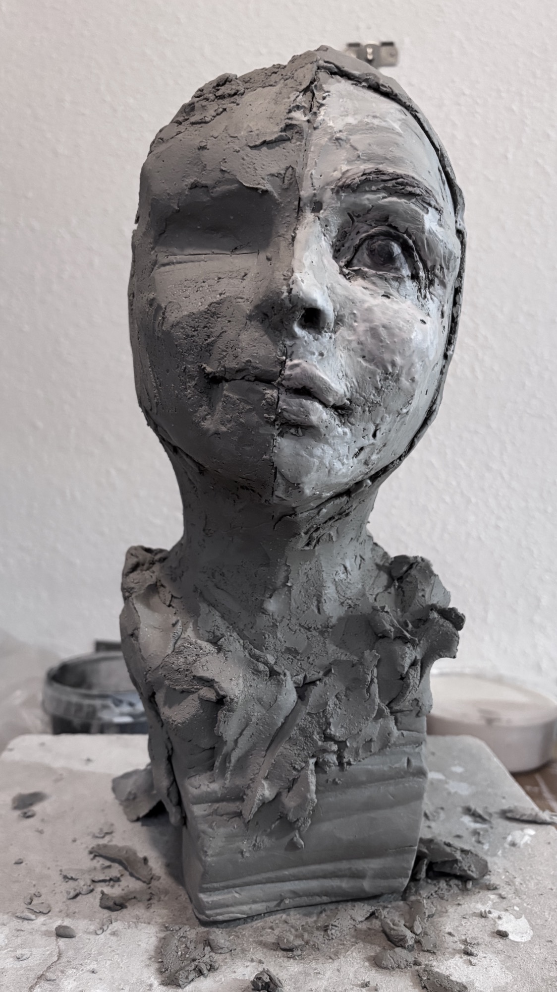 Skulptur eines menschlichen Kopfes aus Ton, unvollständig und mit detailreichen Gesichtszügen.