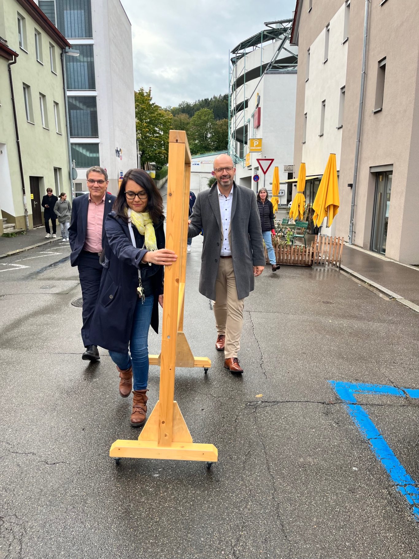 Personen schieben die gestalteten Wände zum Marktplatz.